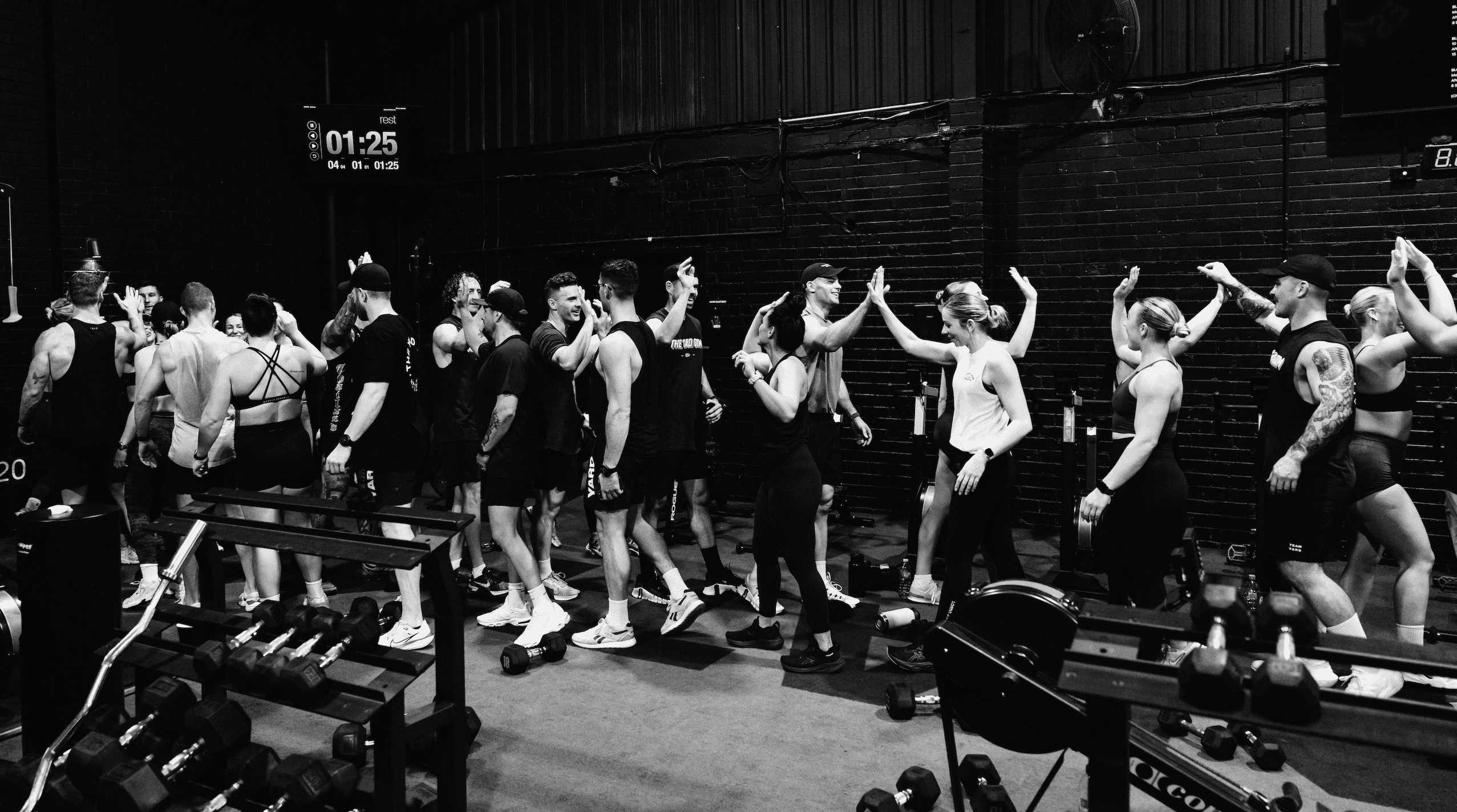 Team members and coaches celebrating after a hybrid training session at The Yard Gym Caringbah, showcasing a supportive and motivating environment.